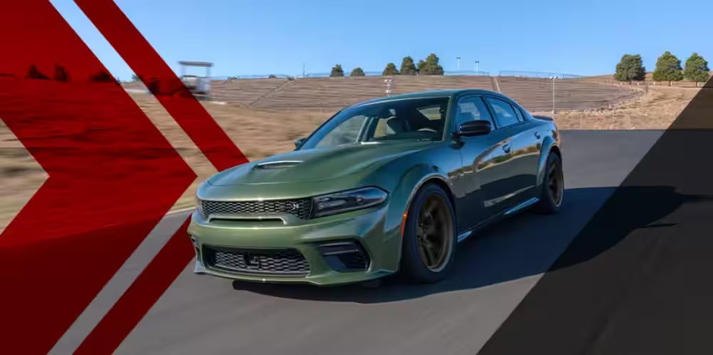 A green charger driving on the road.
