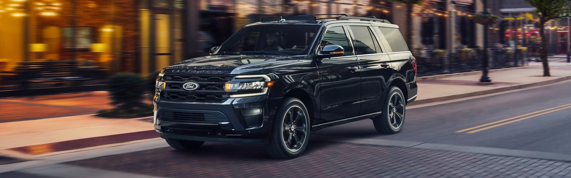 A black suv sitting in the road.