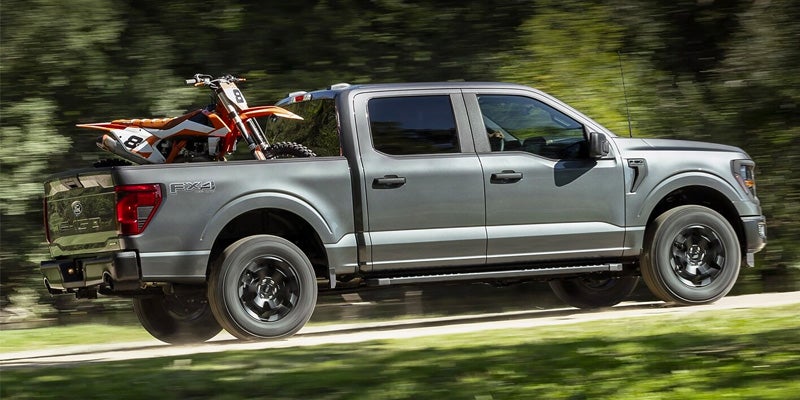 Ford f-150 with dirt bikes in the bed.