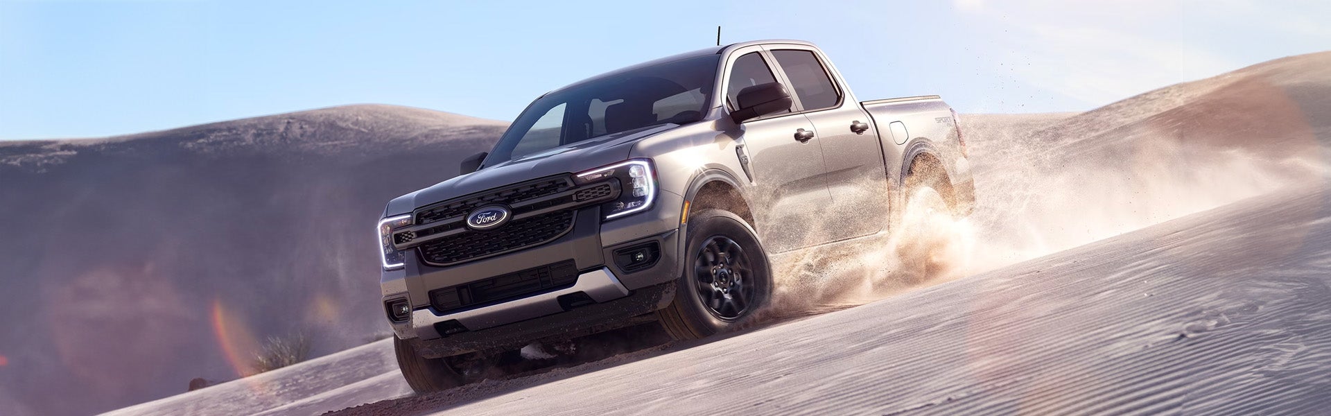 A ford truck driving through the sand.