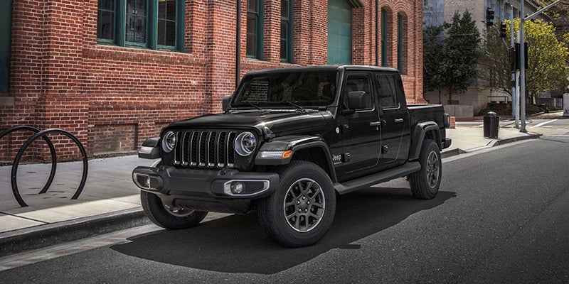A black jeep sitting in the road.