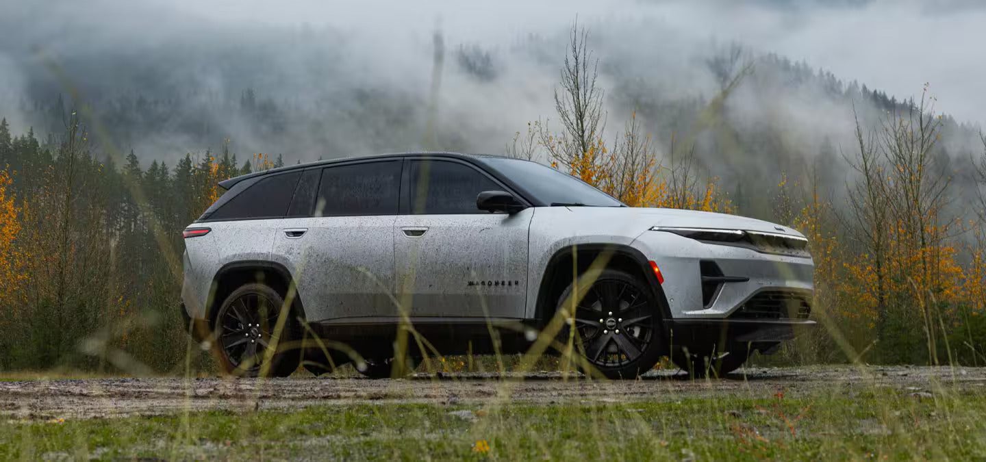 A white suv sitting parked in a field.