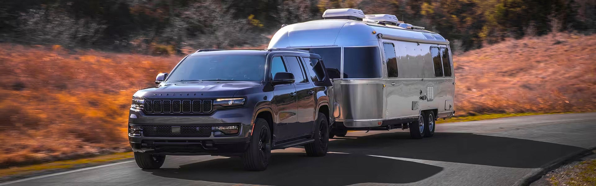 A gray suv pulling a trailer.