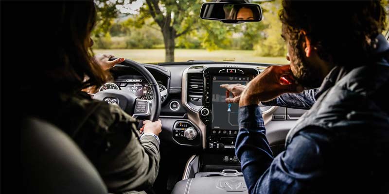 A man and woman sitting inside a ram truck.