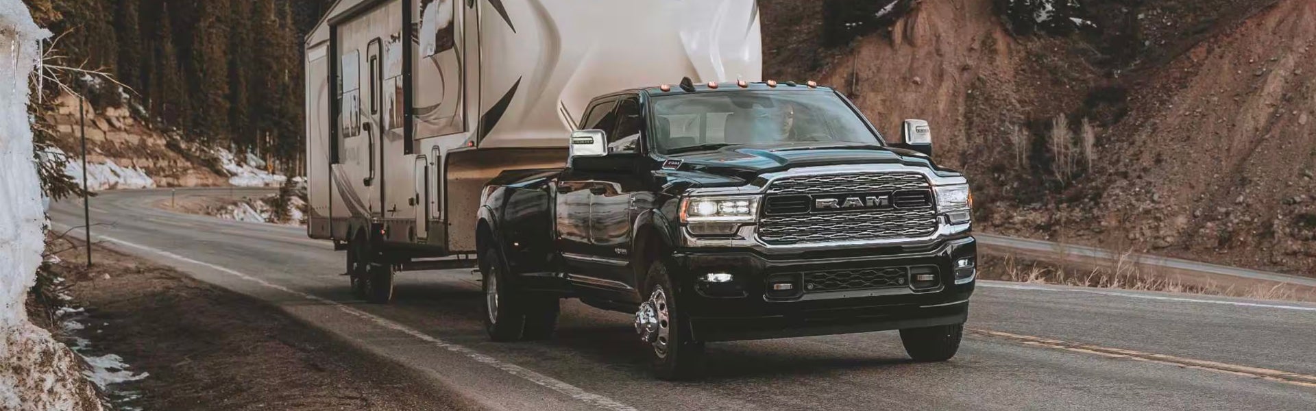 A black truck pulling a trailer.