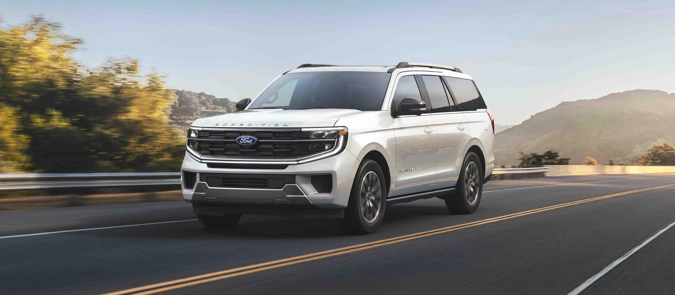 A white suv driving on the road.