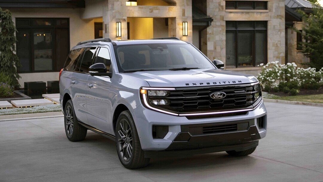 A silver suv sitting parked in a driveway