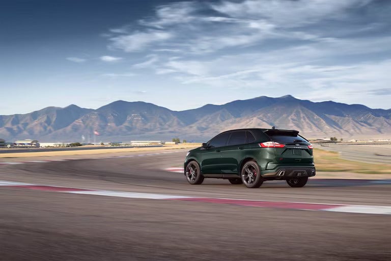 A white suv driving on the road.
