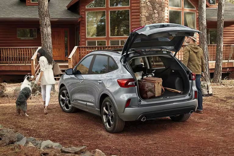 A silver escape parked with the trunk open.