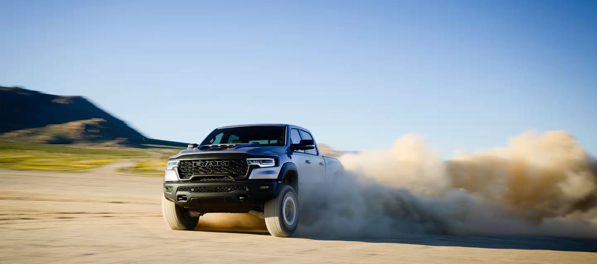 A ram 1500 driving through the sand.