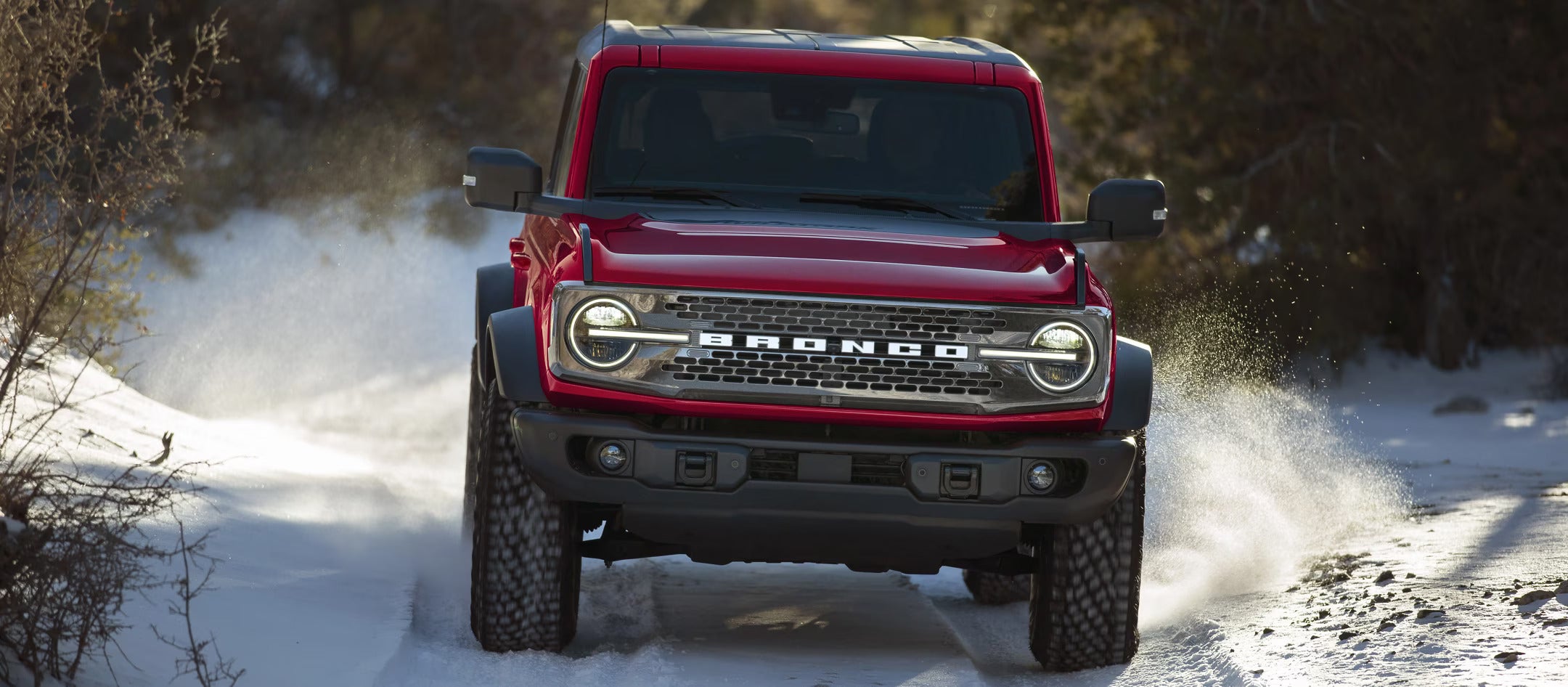 A blue bronco driving on a road.