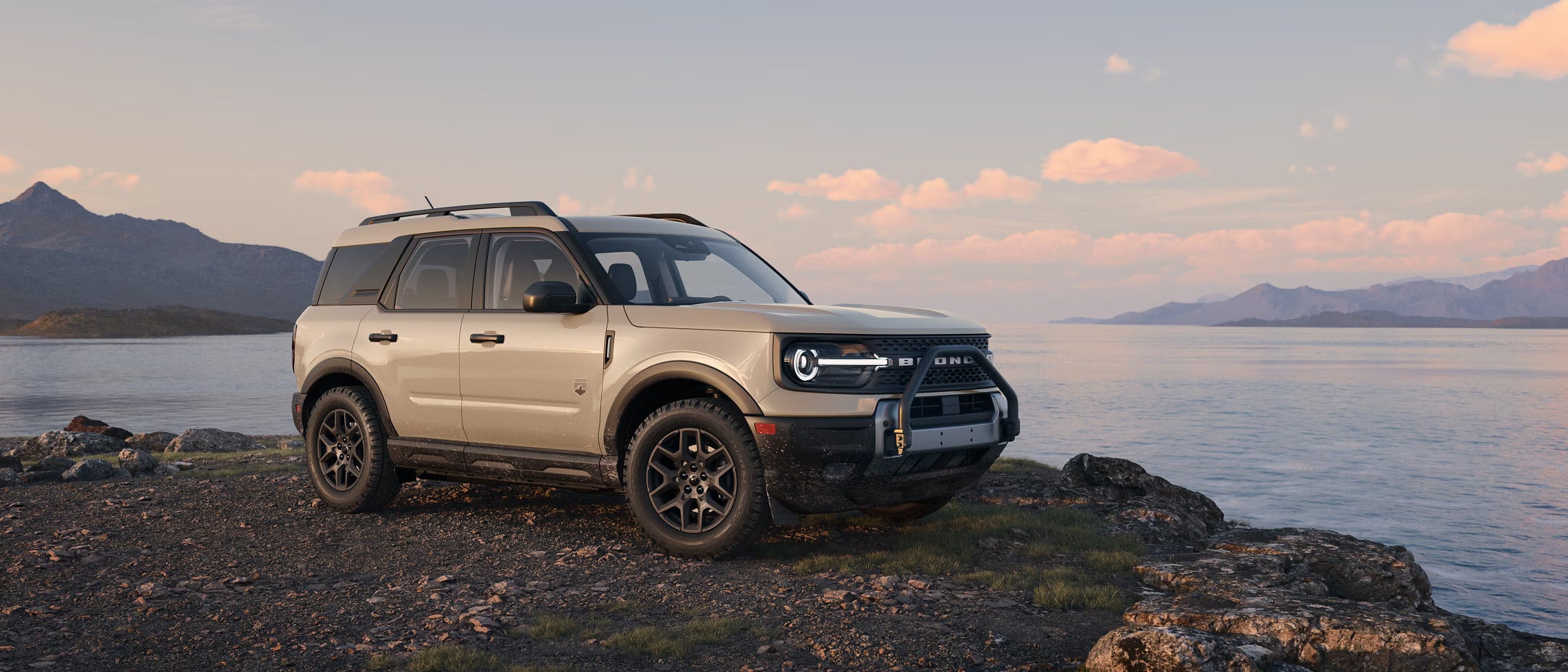 A white bronco sport parked by the water.