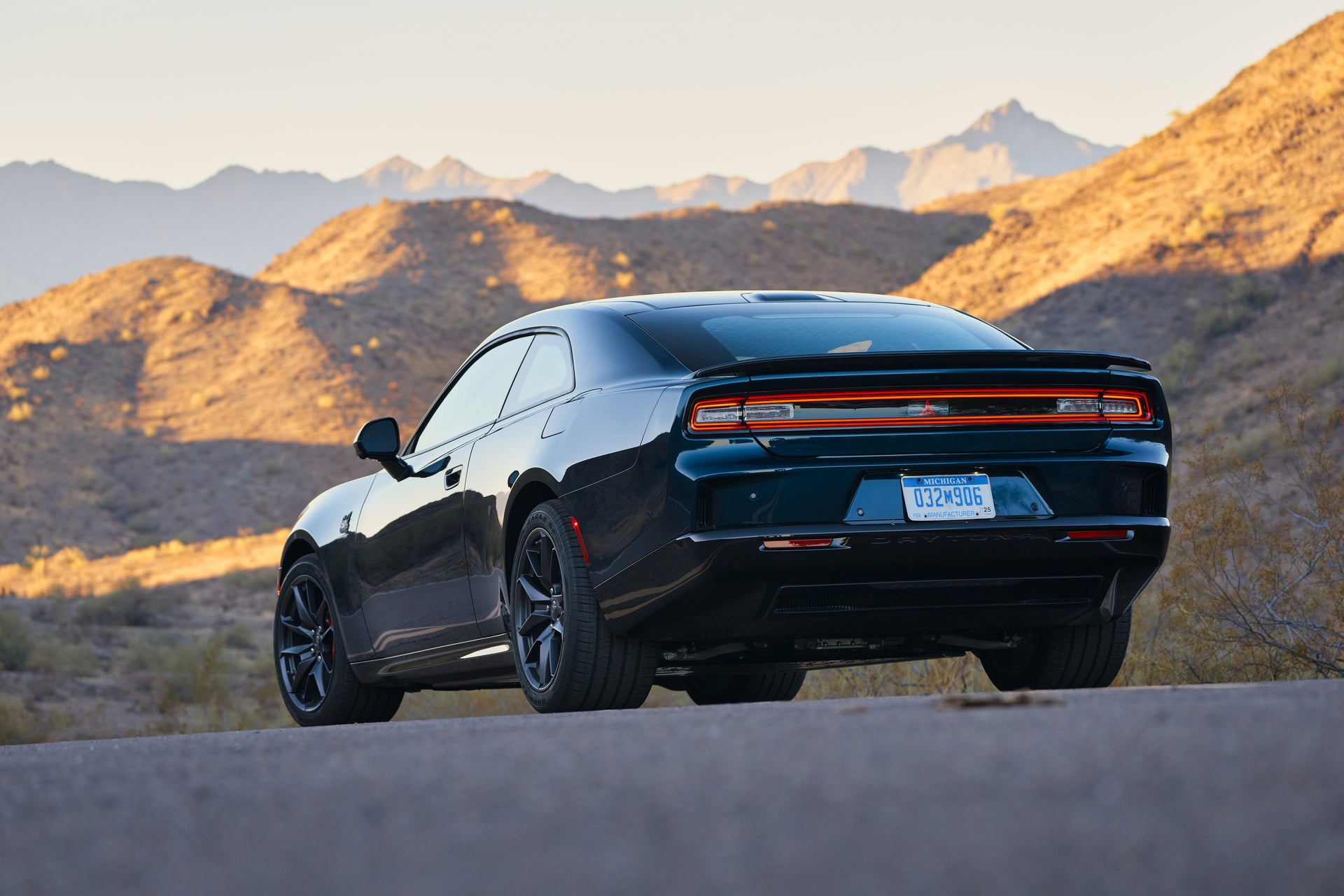 A blue car sitting parked on a road.