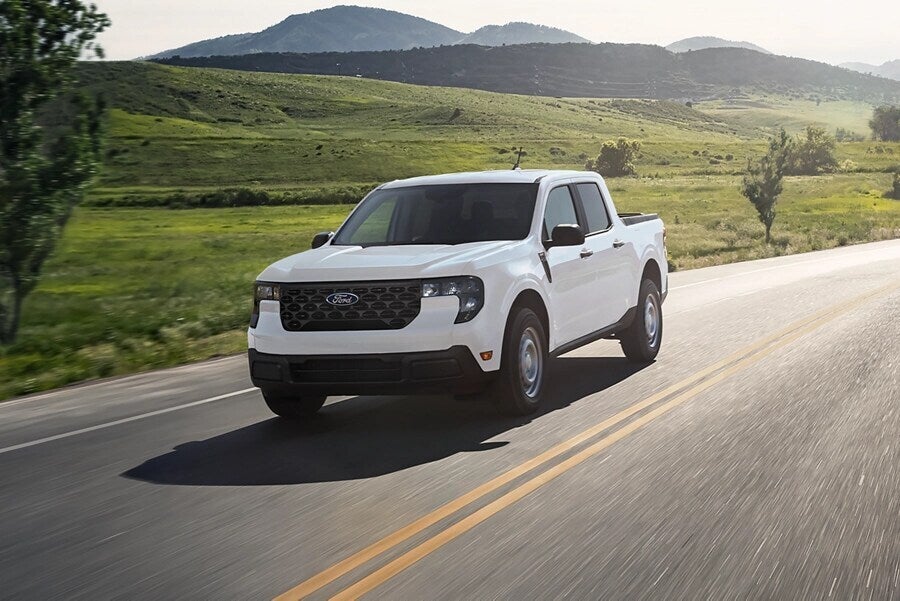 A white truck driving on a road.