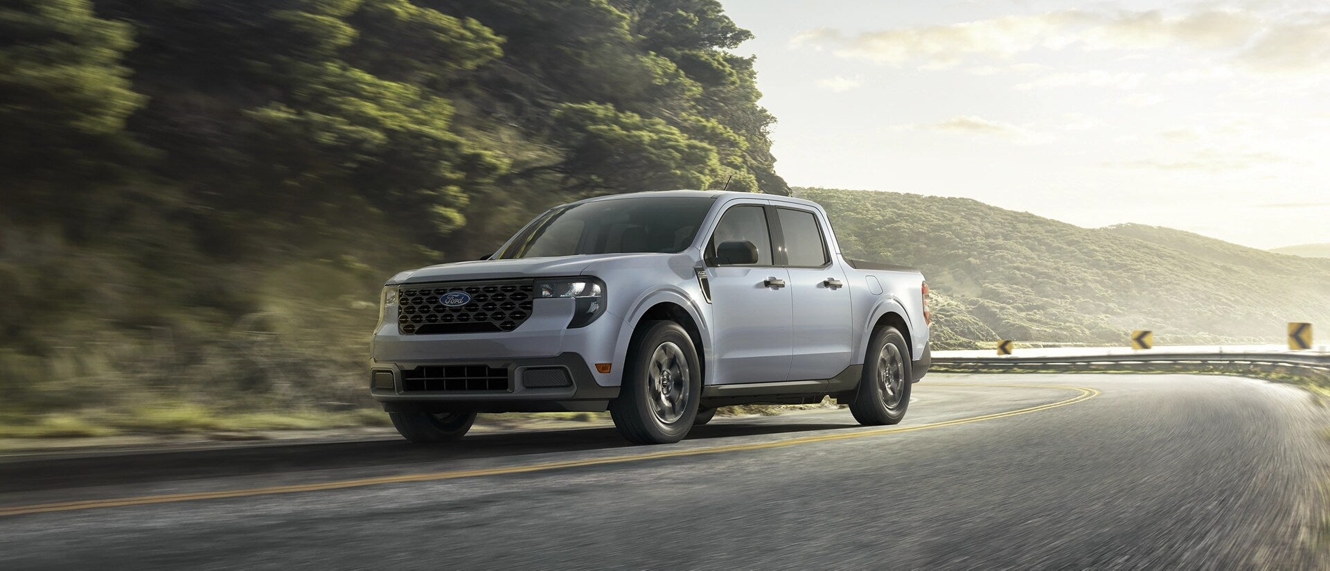 A silver truck driving on the road.