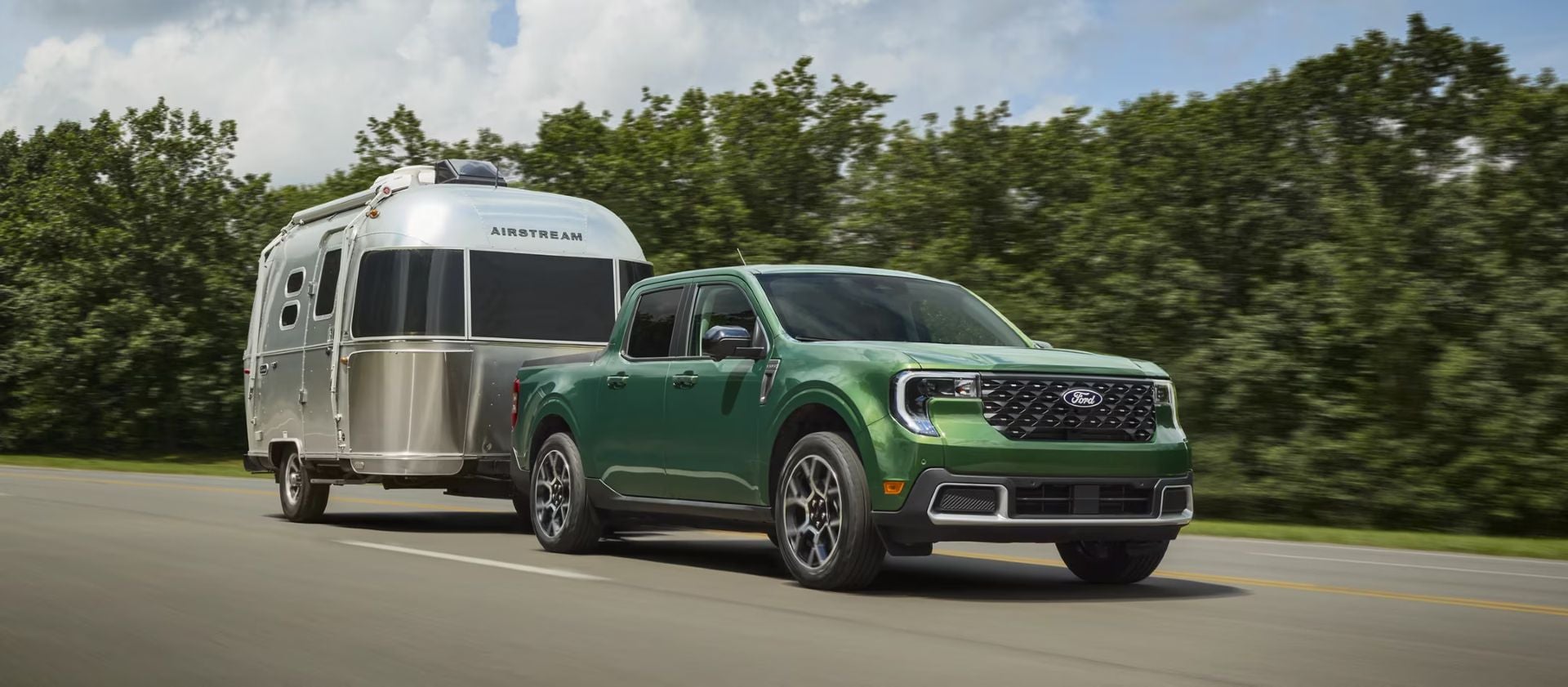 A green truck pulling a mobile home.
