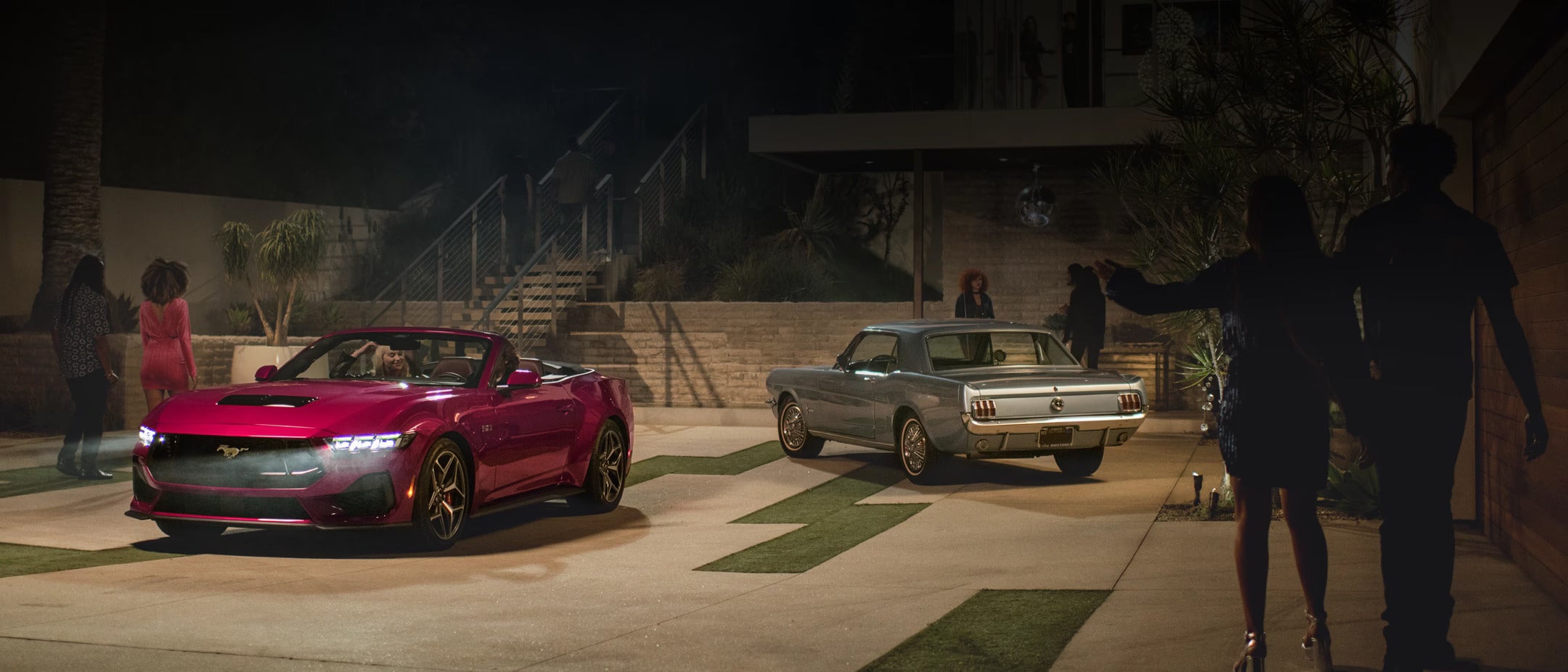 Two cars sitting parked in a yard.