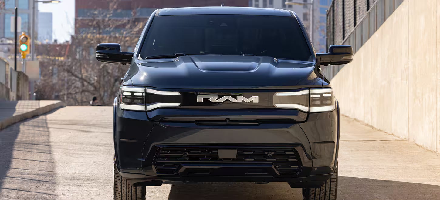 a 2025 ram rev parked next to a bridge in the city