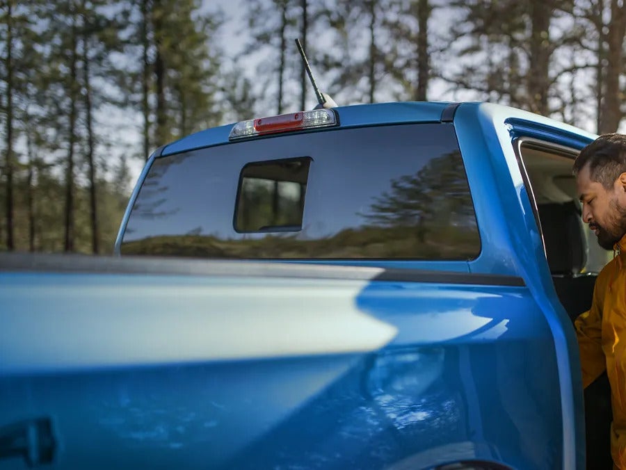 A man getting into the back up a ford ranger.
