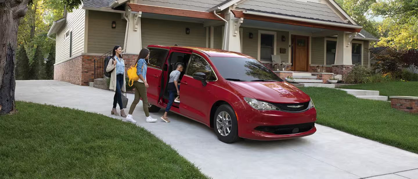 A group of people getting into a red van.
