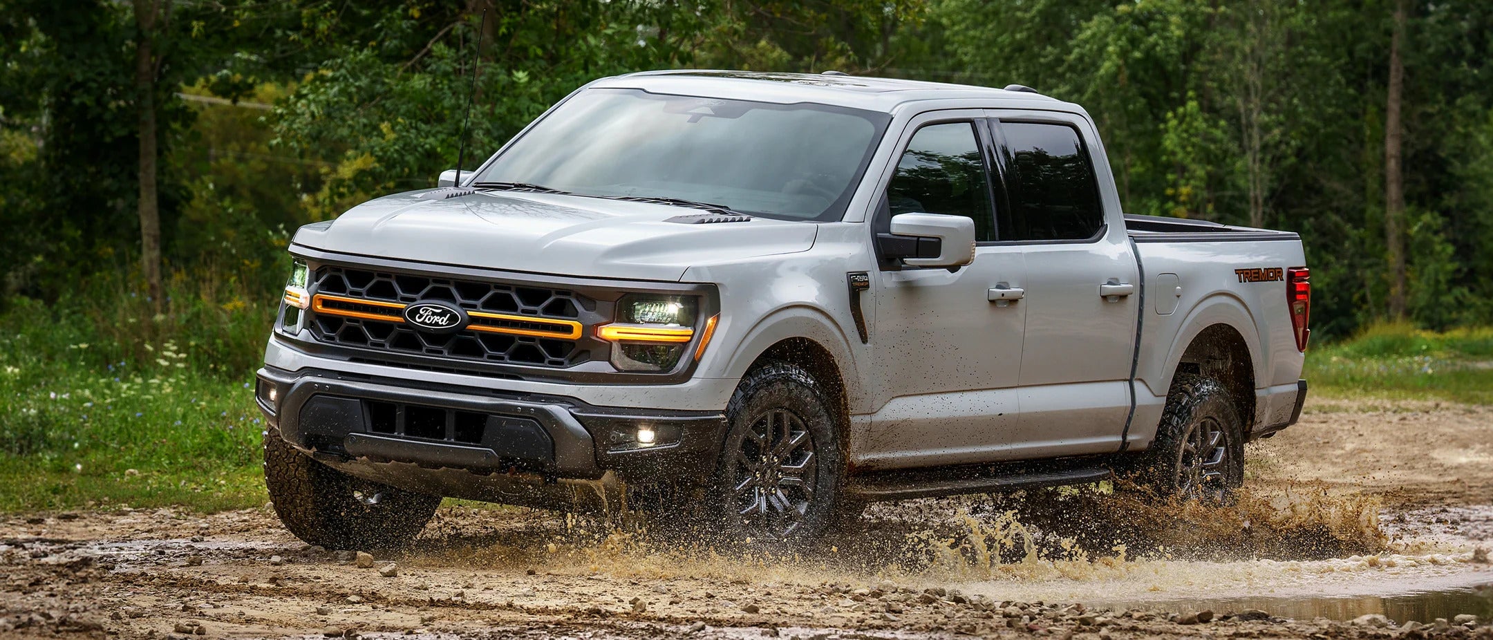 A blue truck pulling a mobile home.