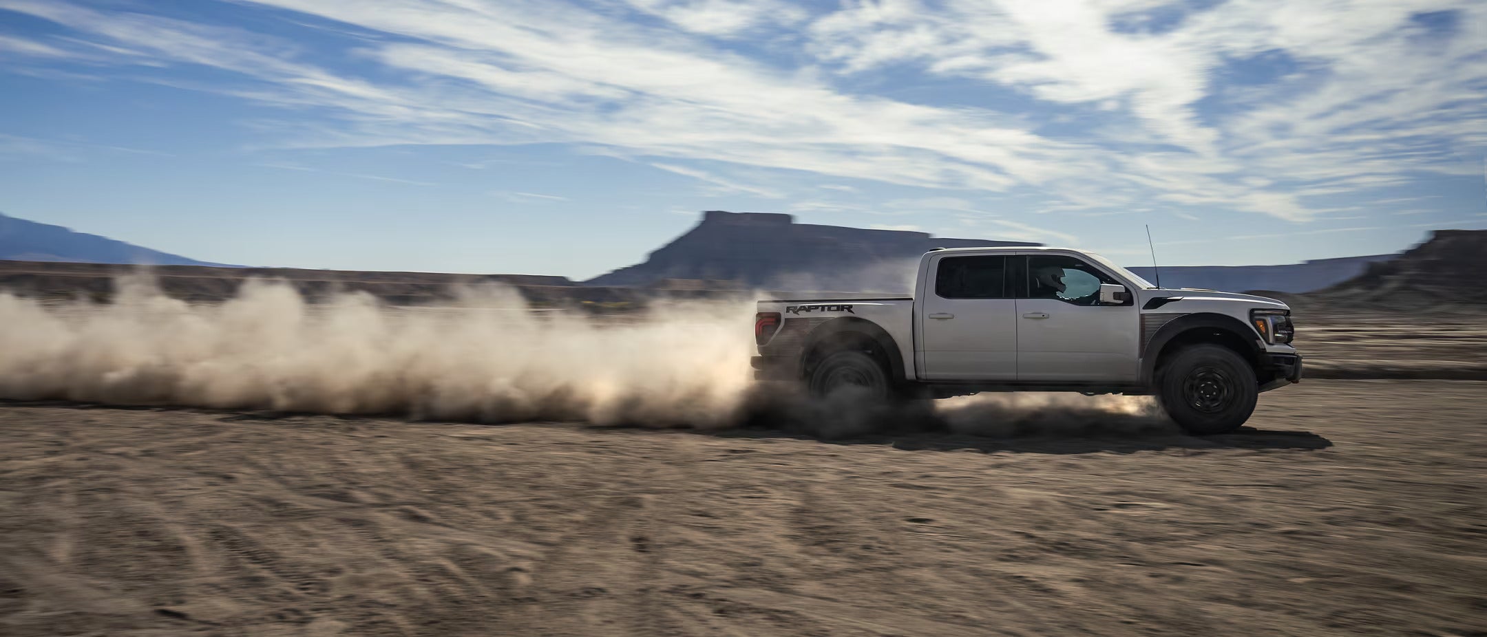 a ford truck driving through the sand.