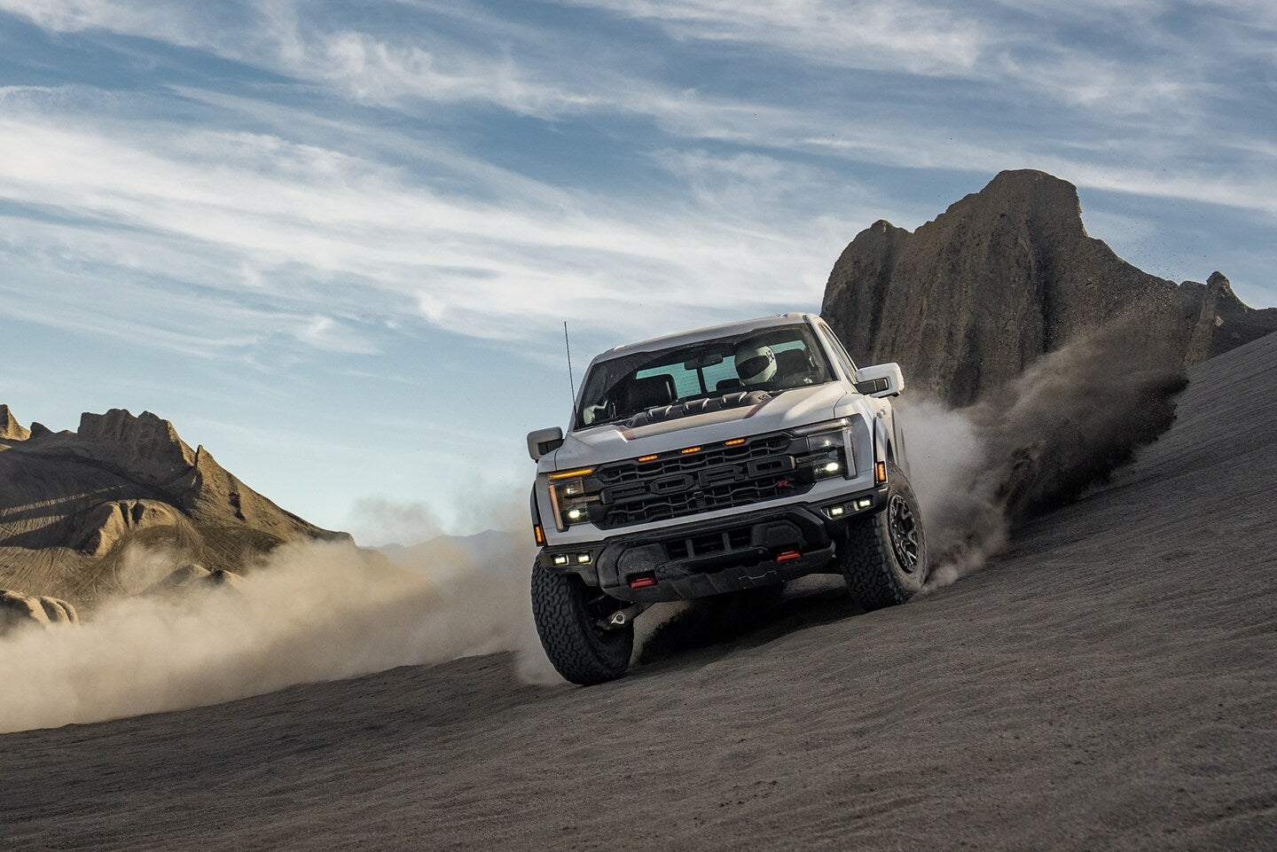 A gray truck driving off-road.