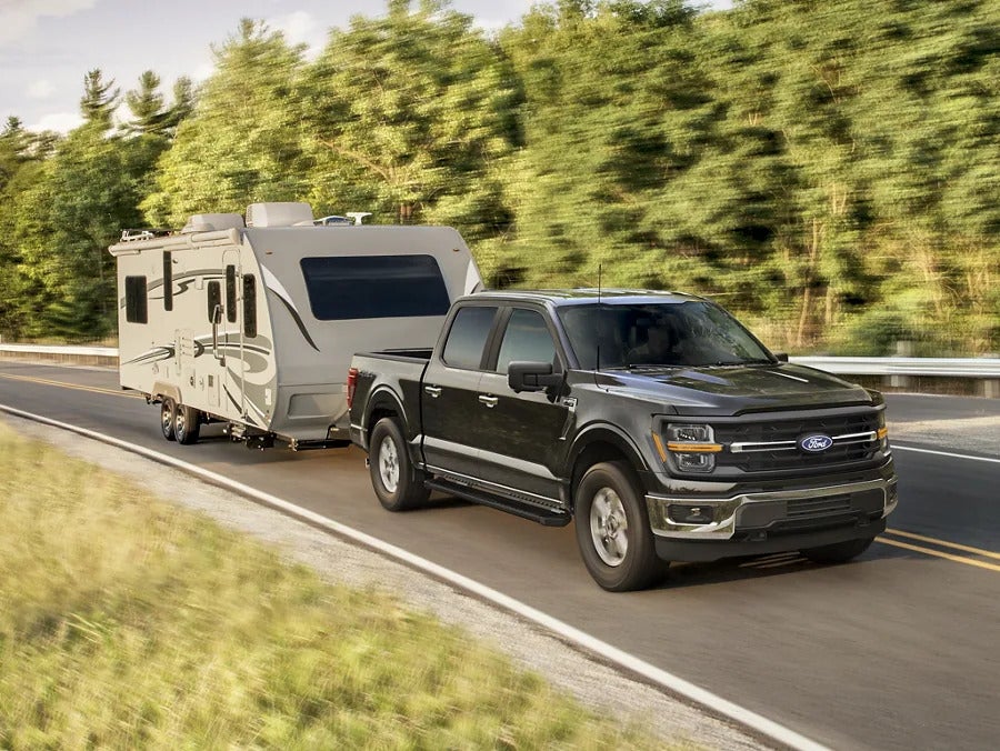 a 2025 ford f-150 hauling a camper trailer on the highway