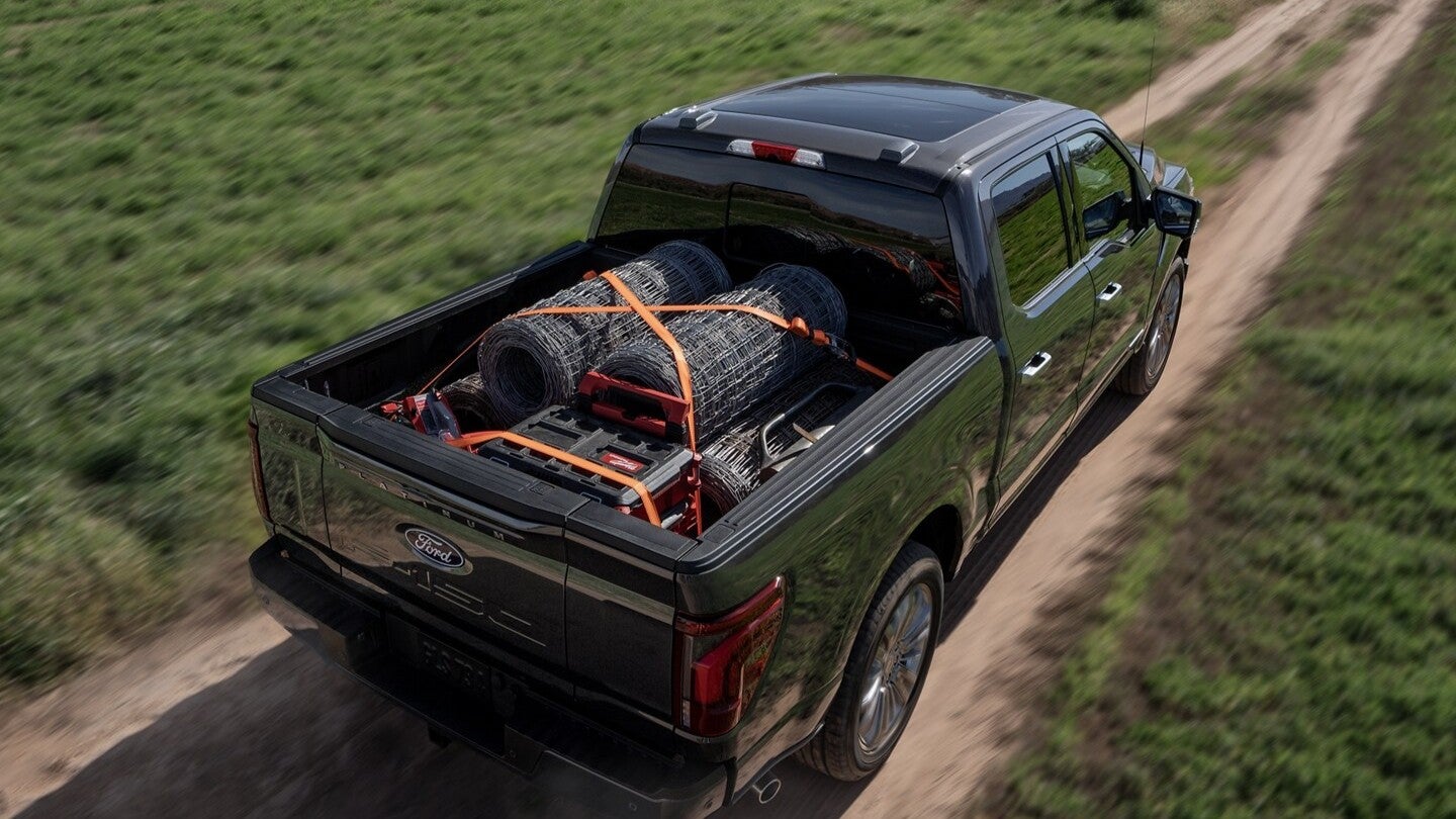 The loaded bed of a Ford F-150 driving on a road.