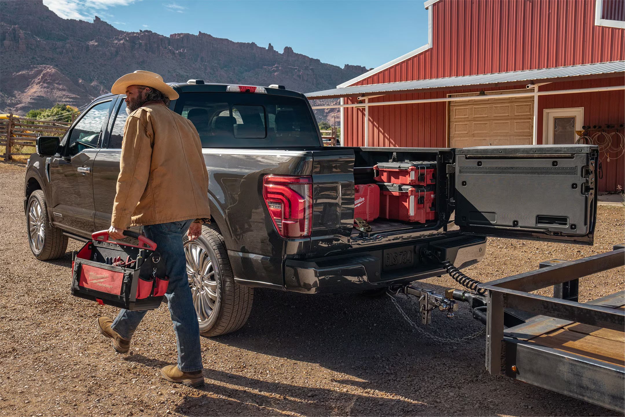A man walking away from the bed of a truck.