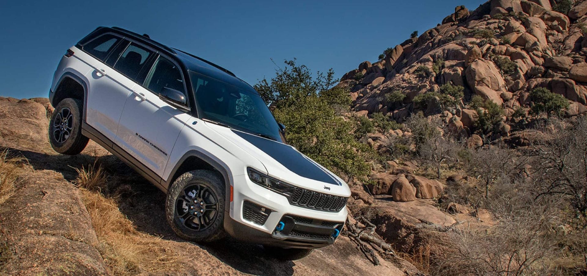 a white jeep driving up a hill.
