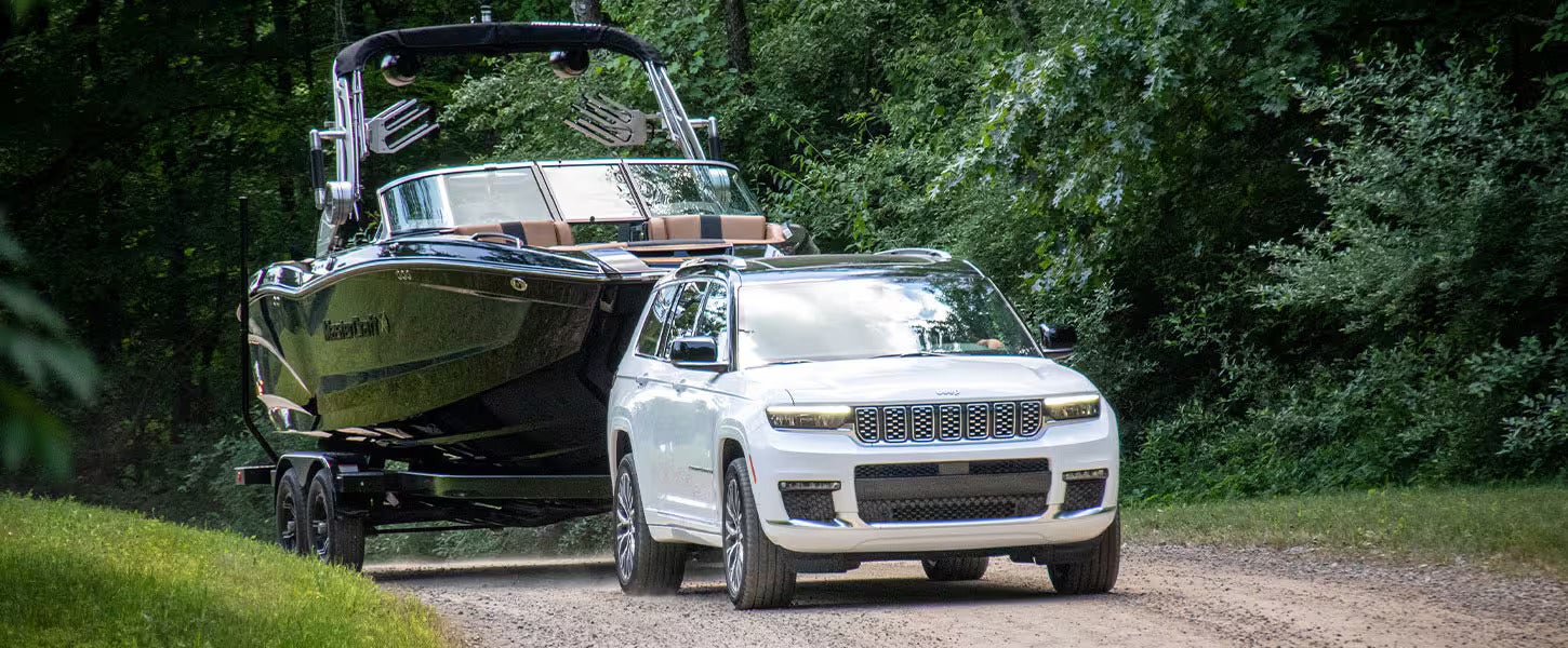 A white cherokee pulling a boat.