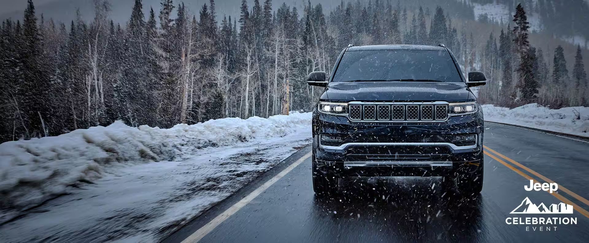 A black suv driving in the snow.