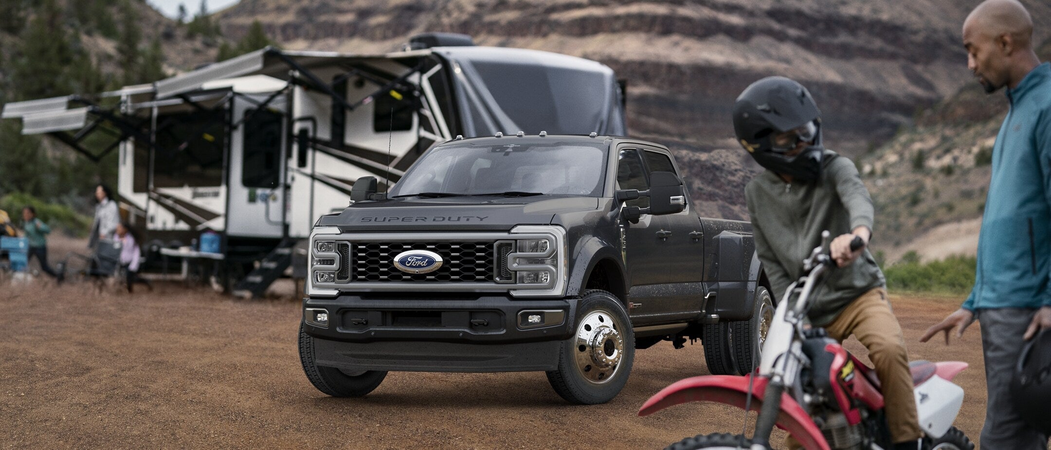 A black truck sitting parked by a mobile home.