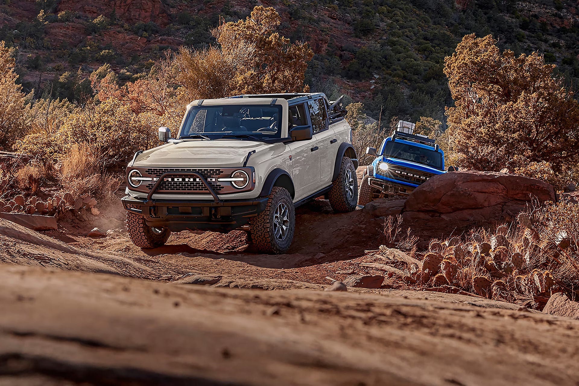 two 2026 ford broncos driving in the desert