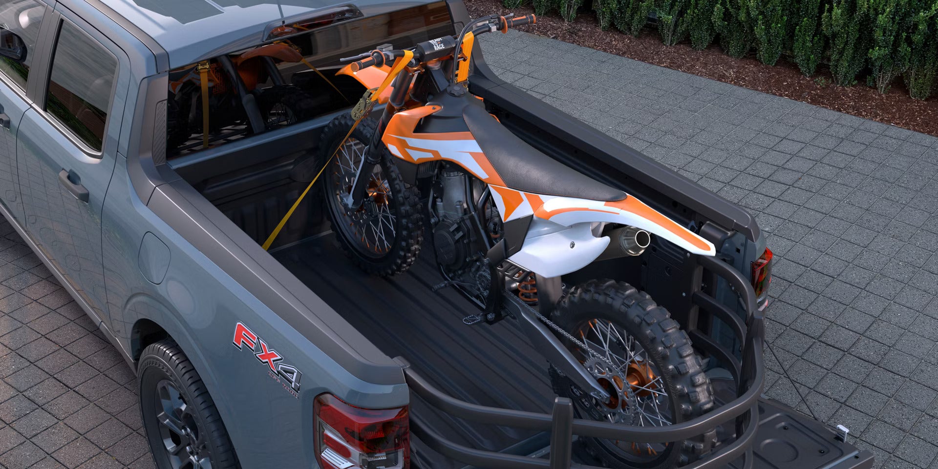 A New 2026 Ford Maverick hauling a dirt bike in the bed of the truck