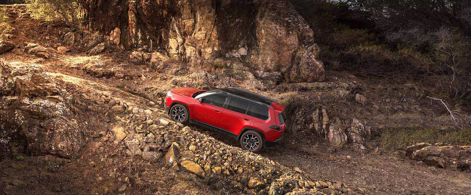 2026 Jeep Cherokee driving up a rocky hill