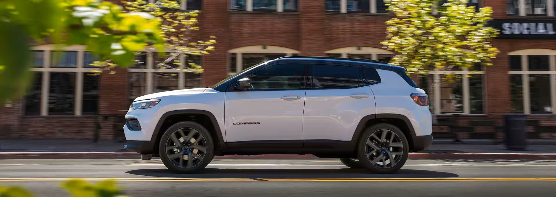 2026 jeep compass parked on a road with the city in the back ground