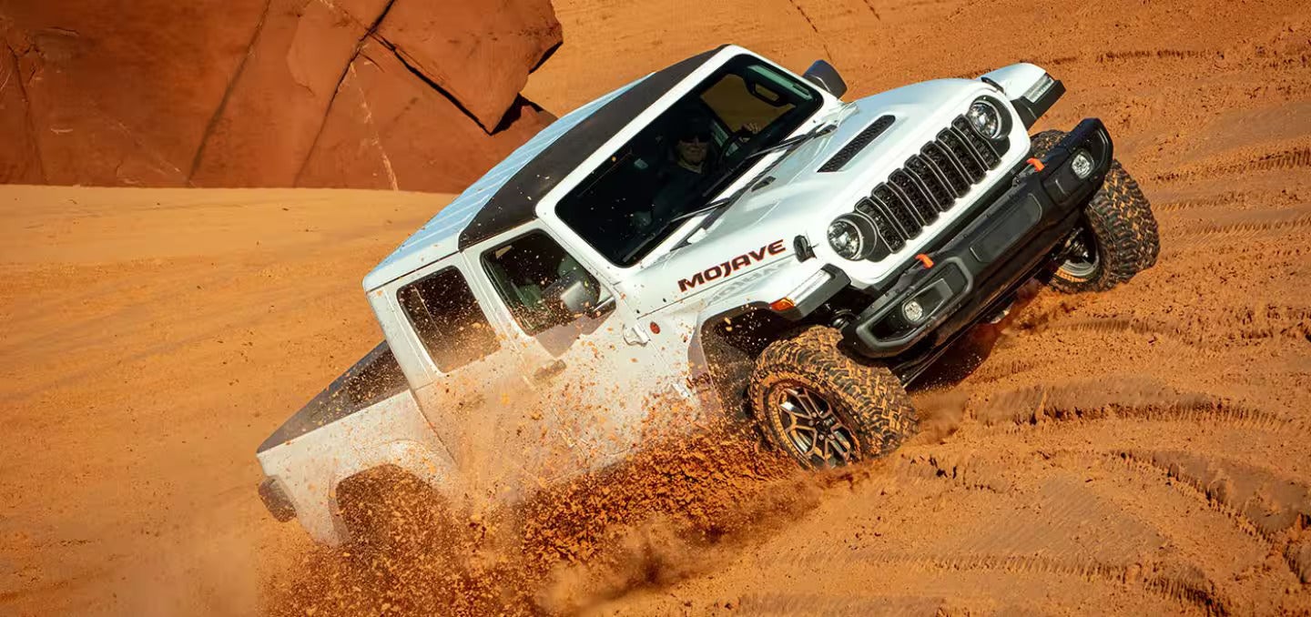 2026 Jeep Gladiator driving up a hill in the desert