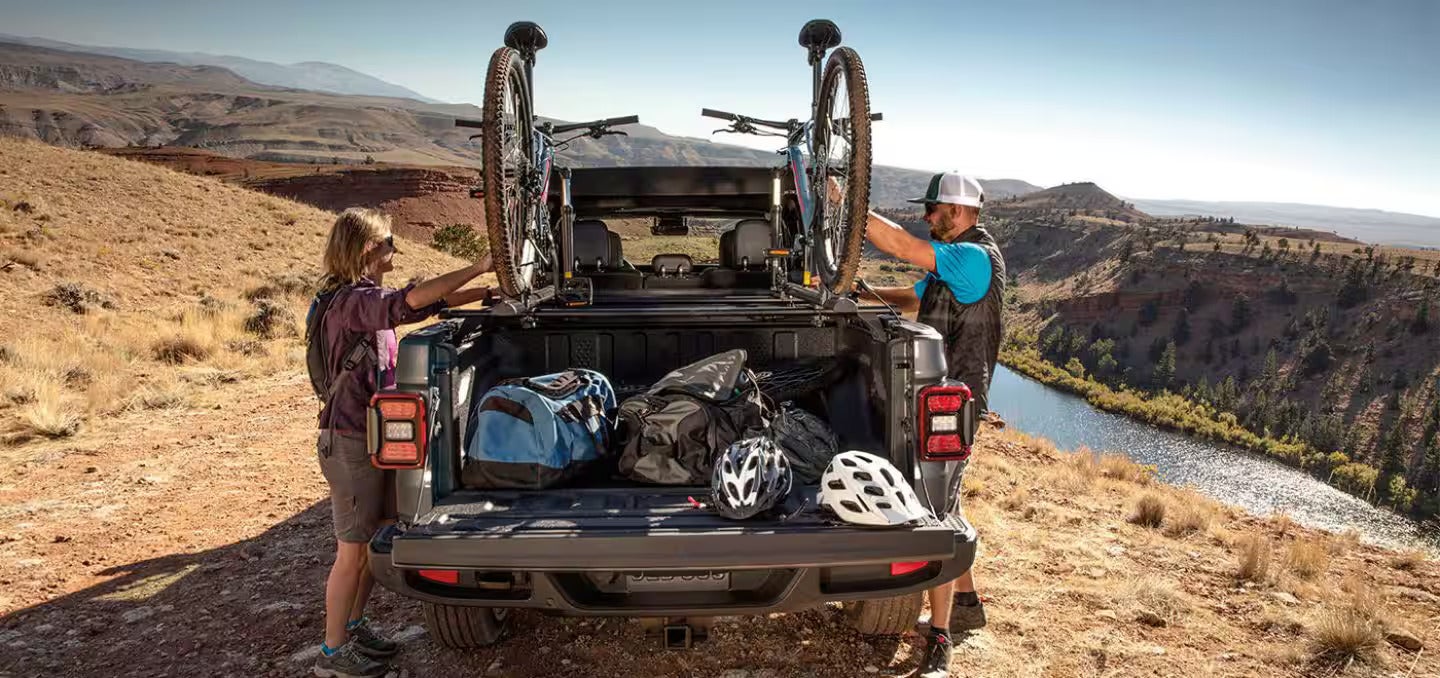 2026 Jeep Gladiator parked on a hill with two bikes in the bed of the gladiator