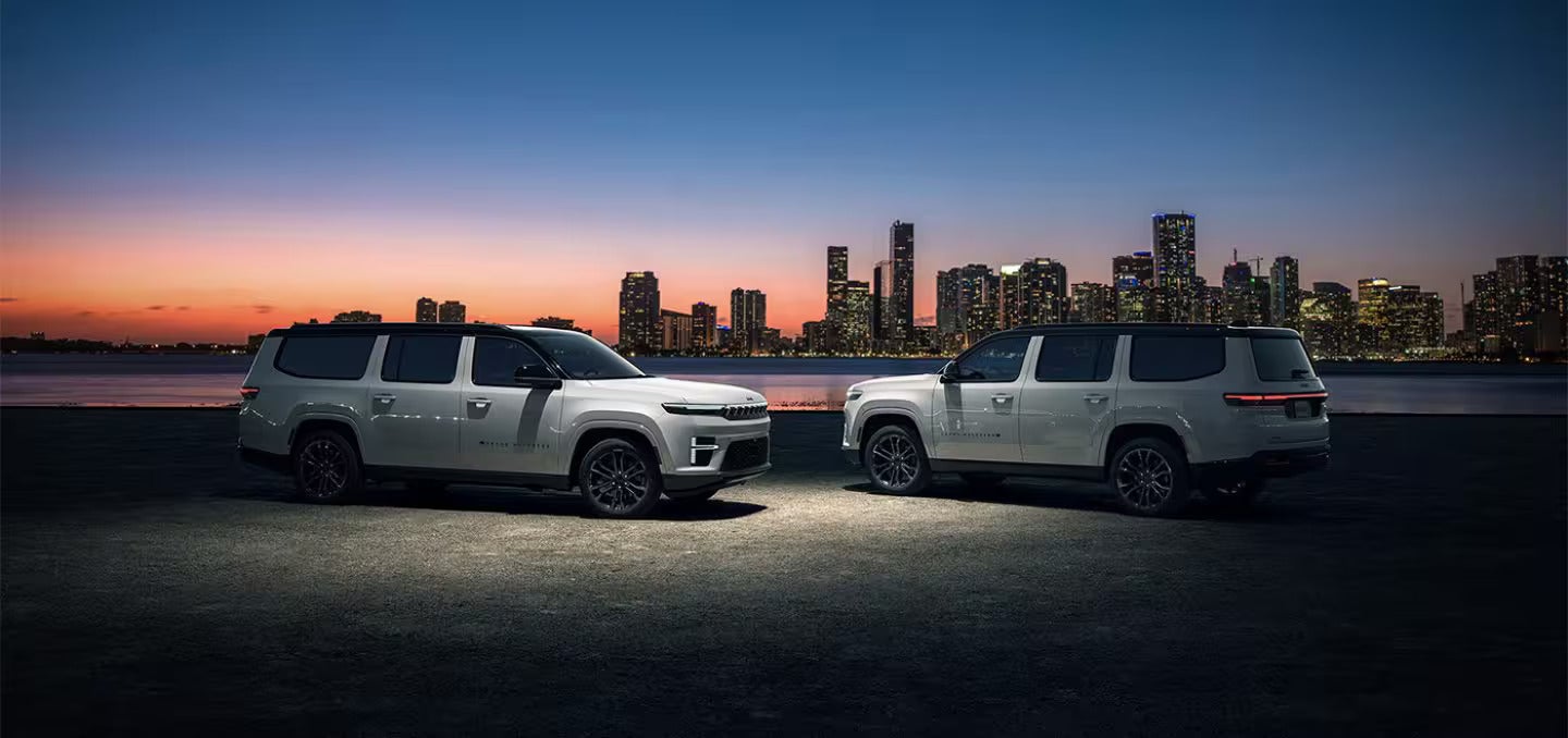 two 2026 Jeep grand Wagoneer's parked in front of the city sky line