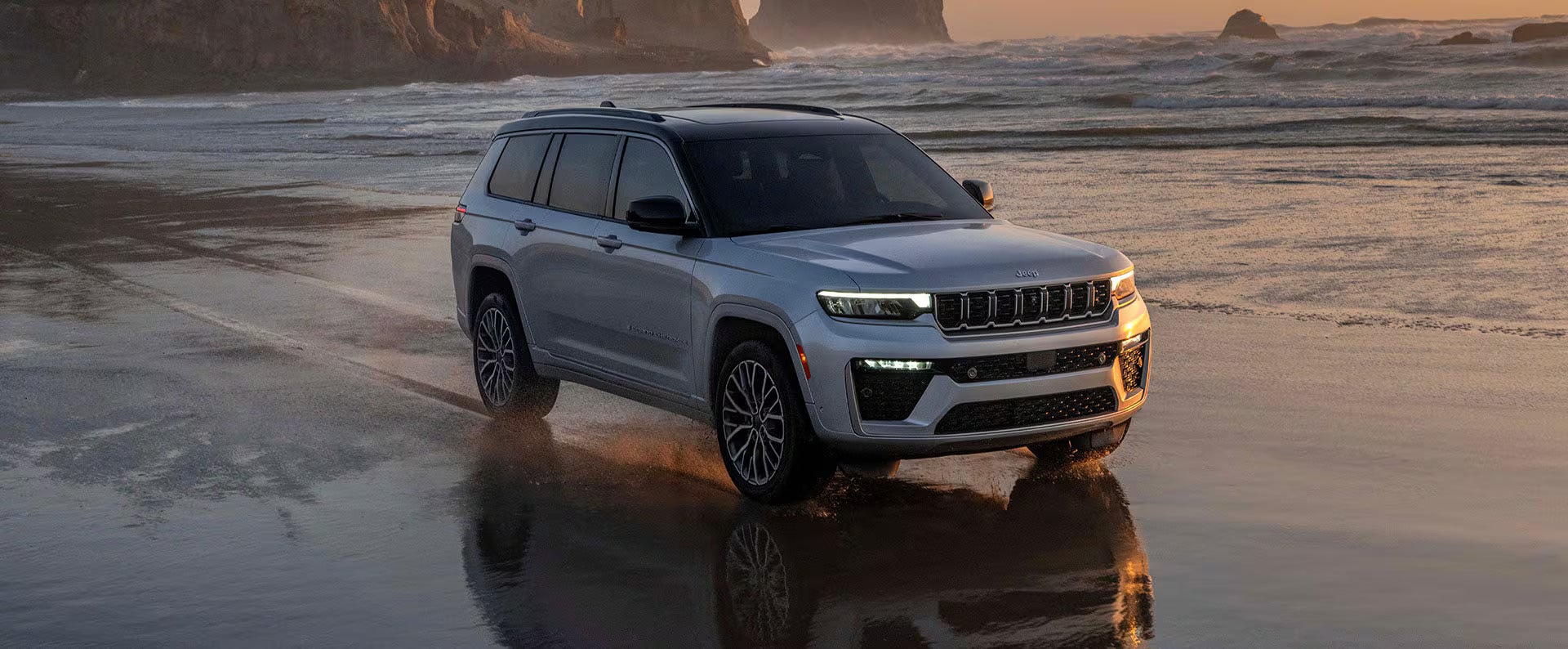 a new 2026 jeep grand cherokee parked on some grass in a field