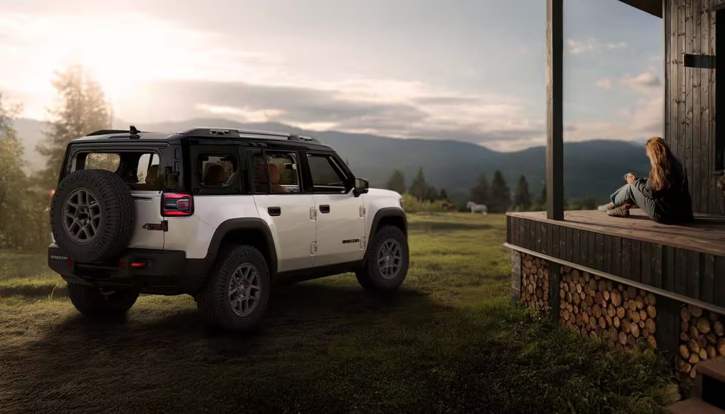 2026 Jeep Recon driving through an open gate on a farm
