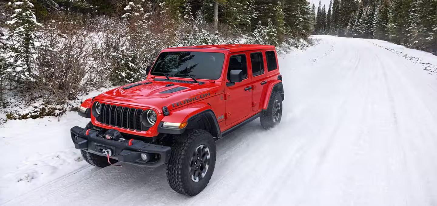 2026 Jeep Wrangler driving on a snow covered road