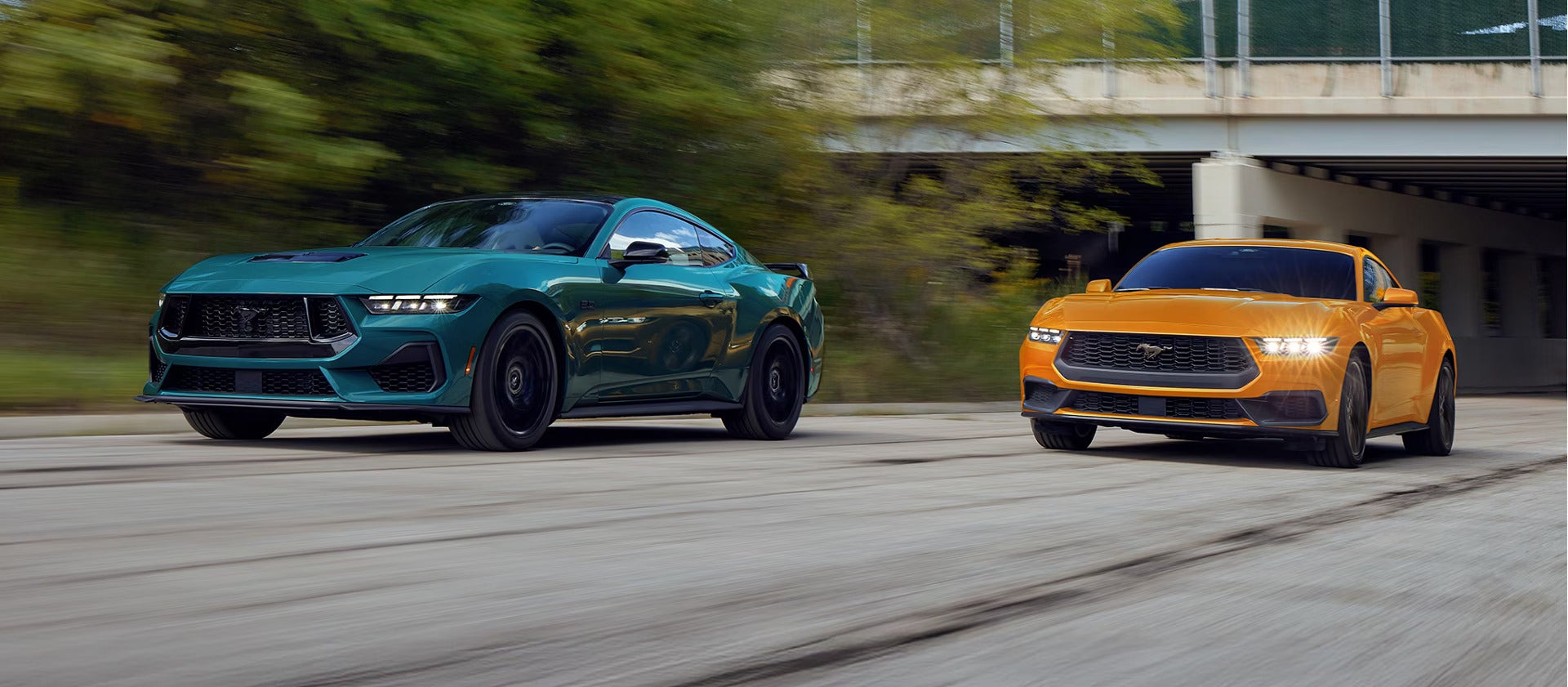 two 2026 ford mustangs driving on a road