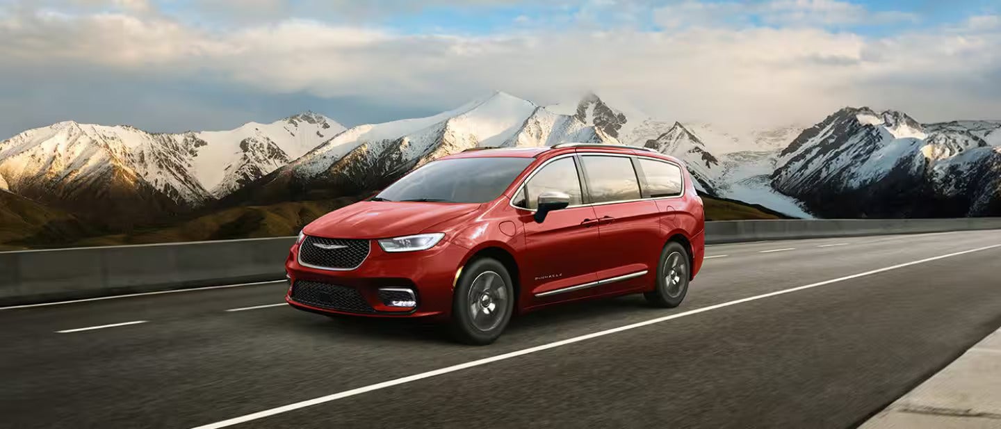 2026 Pacifica Plug-in Hybrid driving on a road with the mountains in the back ground