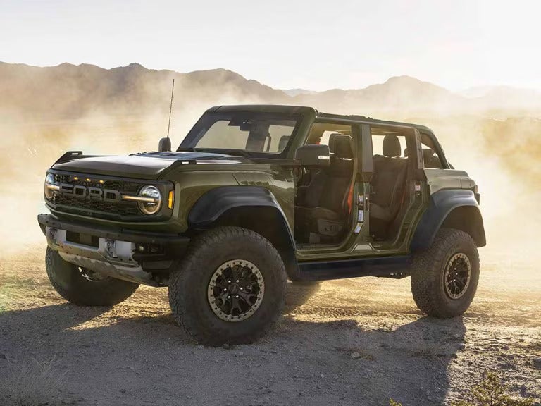 a ford bronco raptor parked next to a dessert terrain