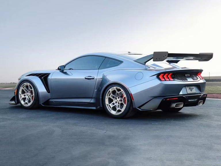 a silver ford mustang GTD parked next to field