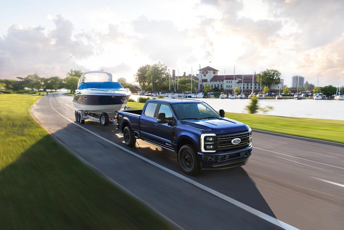 Blue Ford F-350 Super Duty towing a speedboat on a paved lakeside road near Junction City, Kansas