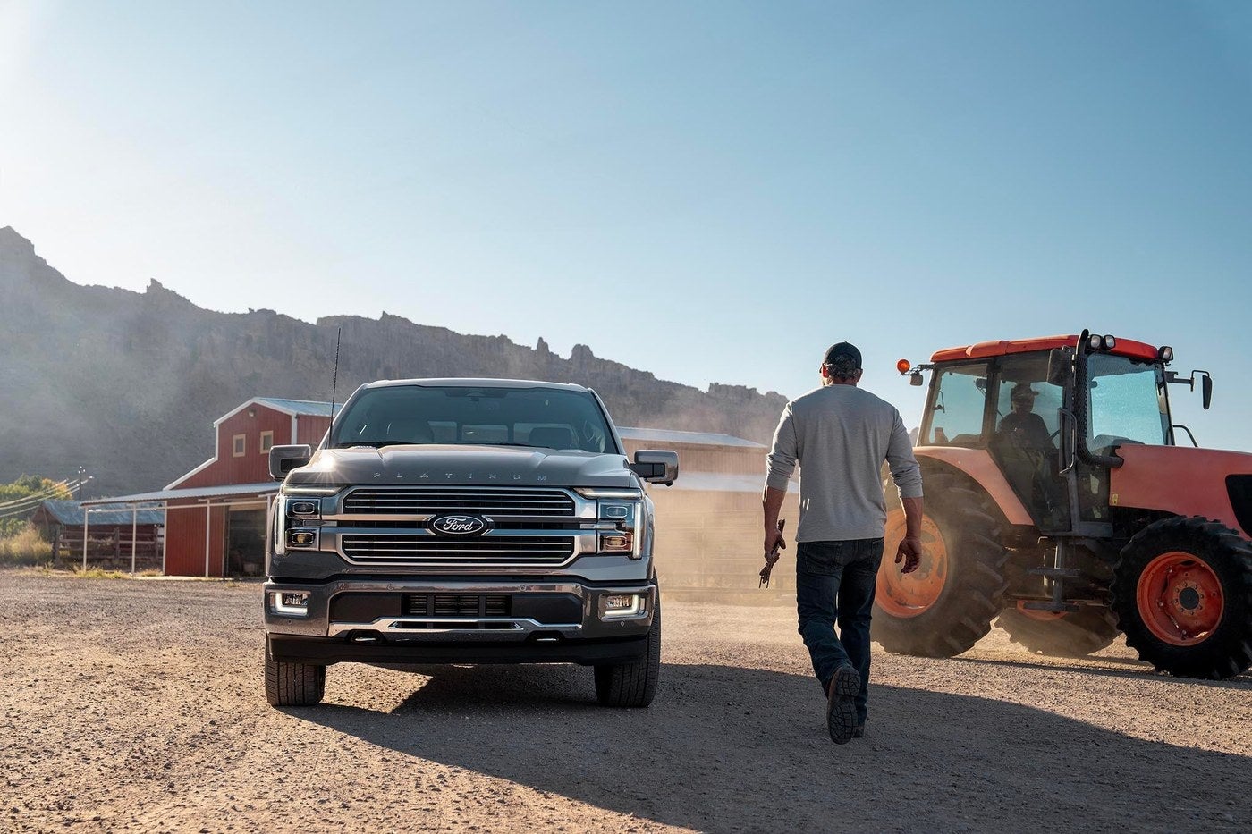 Ford F-150 parked at a Kansas farm while a man walks toward a tractor, shopping Valor Ford in Junction City